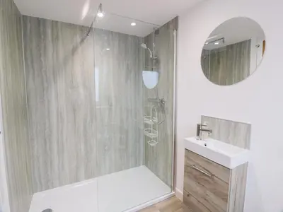 a bathroom with a shower and a sink and a mirror at Beach House in Stranraer
