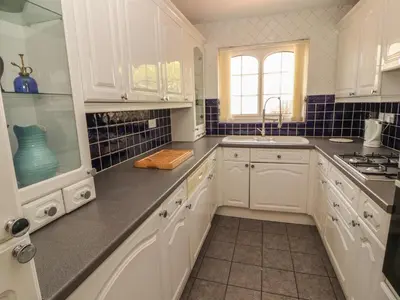 a white kitchen with white cabinets and a sink at 3 Hawk Place in Whitehaven