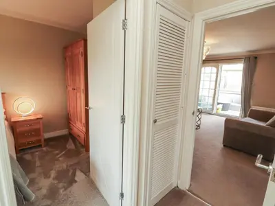 a room with a closet with a couch and a window at 3 Hawk Place in Whitehaven