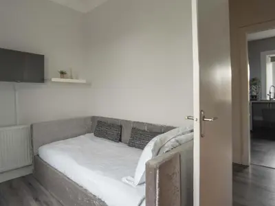 a bed with white sheets and pillows in a room at Pitchside Escape in Ayr