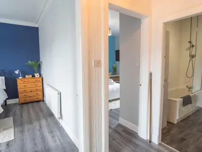a room with a bathroom with a tub and a bedroom at Pitchside Escape in Ayr