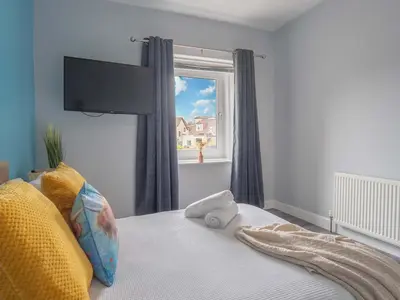 a bedroom with a bed with a large window at Pitchside Escape in Ayr
