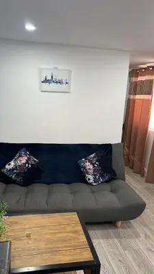 a living room with a couch and a table at Love Shack - Cozy 1BR Walthamstow in Moffat