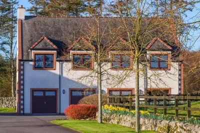 a white house with a brown roof at Hill View at Kenmuir in Dalbeattie