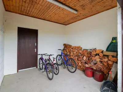 two bikes parked in a room with a pile of logs at Hill View at Kenmuir in Dalbeattie