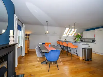 a kitchen and dining room with a table and chairs at Hill View at Kenmuir in Dalbeattie