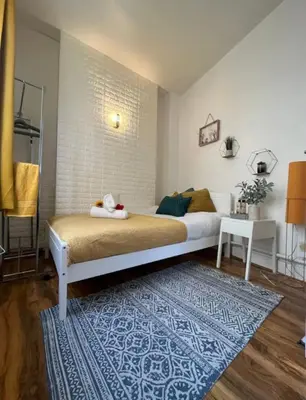 a bedroom with a bed and a blue rug at Apartment in the heart of London in Moffat