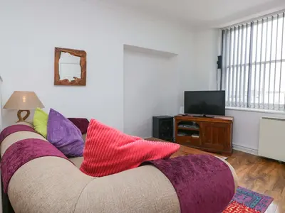 a living room with a couch with colorful pillows at Duncan Square in Whitehaven