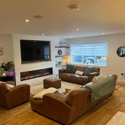 a living room with two couches and a fireplace at The Fishermans Rest in Castle Douglas