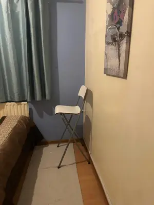a white chair in a corner of a room at Home Sweet Home in Moffat