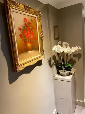 a painting of a vase of flowers on a wall at Elegant Chelsea Apartment in Moffat