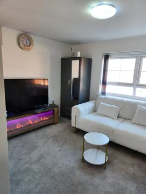 a living room with a white couch and a fish tank at Edinburgh Road Nuneaton in Moffat