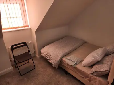 a small bedroom with a bed and a chair at Edinburgh Road Nuneaton in Moffat