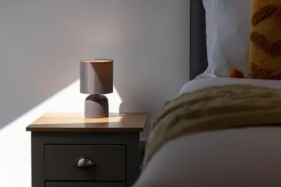 a lamp on a night stand next to a bed at No20 Mansfield - Donnini Apartments in Prestwick