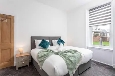 a white bedroom with a large bed with a window at No20 Mansfield - Donnini Apartments in Prestwick