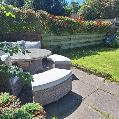 a patio with a table and chairs in a garden at Shoreside in Powfoot