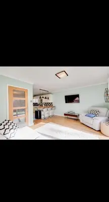 a living room with two couches and a tv at Modern home Close to all Cardiff venues in Moffat