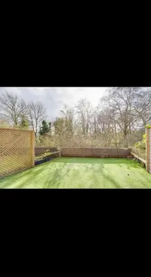 a large yard with a fence and a tennis court at Modern home Close to all Cardiff venues in Moffat