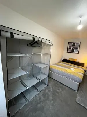 a bedroom with a bed and a closet with shelves at Vibrant Room in Centeral Ayr in Ayr