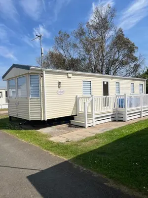 a white mobile home with a white fence at Static Caravan in Moffat