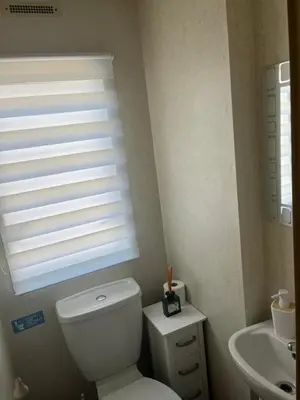 a bathroom with a white toilet and a sink at Static Caravan in Moffat