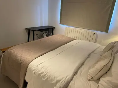 a bed in a bedroom with a table on a wall at Detached Annexe in Moffat
