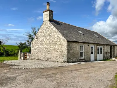 an old stone building with a chimney on top at Landberrick Farm Bothy in Mochrum