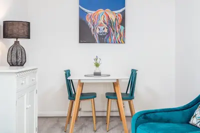 a dining room with a table and two chairs at Albyn Retreat - Donnini Apartments in Prestwick