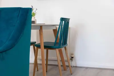 a dining room table with a blue chair next to it at Albyn Retreat - Donnini Apartments in Prestwick
