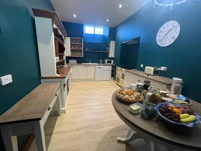a blue kitchen with a table with fruit on it at Craigielands House in Beattock