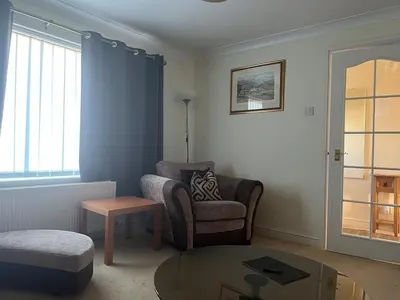 a living room with a chair and a coffee table at 2 bedroom Lake district cottage in Cockermouth
