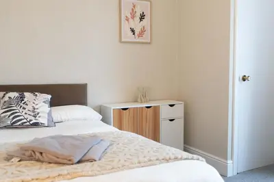 a bedroom with a bed and a dresser with a picture at Saint Nico in Carlisle