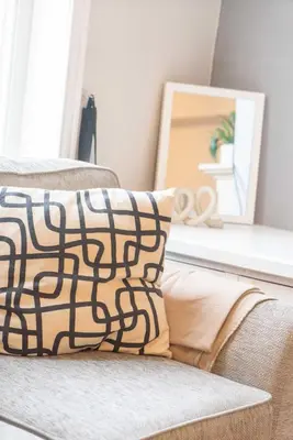 a couch with a pillow and a mirror in a room at Saint Nico in Carlisle