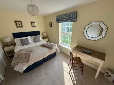 a bedroom with a bed and a mirror and a desk at Burn Bungalow, Longtown ideal for stop overs when travelling, 5 minutes from the M6 in Longtown