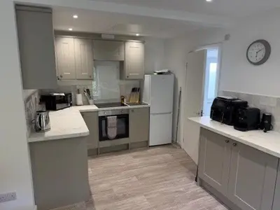 a kitchen with white cabinets and a white refrigerator at Burn Bungalow, Longtown ideal for stop overs when travelling, 5 minutes from the M6 in Longtown