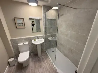 a bathroom with a shower and a toilet and a sink at Burn Bungalow, Longtown ideal for stop overs when travelling, 5 minutes from the M6 in Longtown