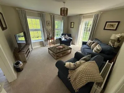 a living room with two couches and a table at Burn Bungalow, Longtown ideal for stop overs when travelling, 5 minutes from the M6 in Longtown