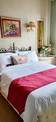 a bedroom with a large bed with a red and white blanket at Ash Lodge at The Barn in Gosforth