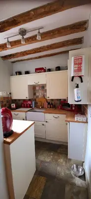 a kitchen with white cabinets and a counter top at Ash Lodge at The Barn in Gosforth