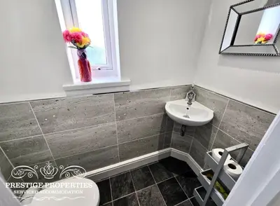 a bathroom with a sink and a toilet and a window at 12 Seacote Garden by Prestige Properties SA in St Bees