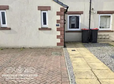 a house with two windows and a brick sidewalk at 12 Seacote Garden by Prestige Properties SA in St Bees