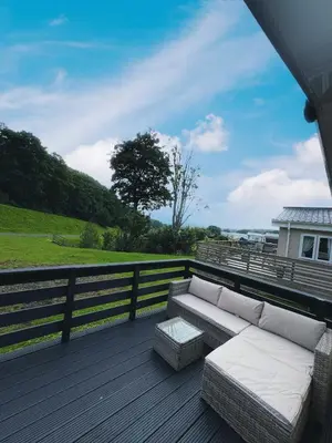 a couch on a deck with a view of a field at Moselle - 6 Squirrel View in Ballantrae