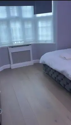a bedroom with a bed and a radiator and windows at 2Bedrooms flat in knightstbridge in Moffat