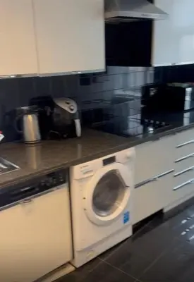 a kitchen with a washing machine under a counter at 2Bedrooms flat in knightstbridge in Moffat