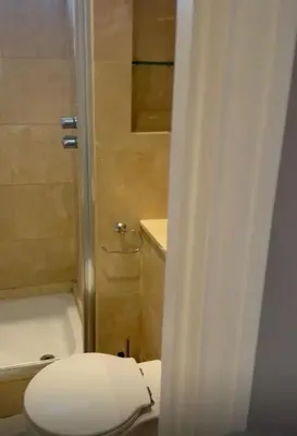 a bathroom with a white toilet and a shower at 2Bedrooms flat in knightstbridge in Moffat