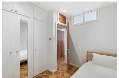 a white bedroom with a bed and a window at 2 Bedroom Apartment Queensway in Moffat