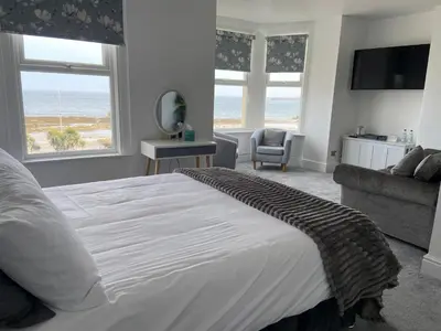 a bedroom with a bed with a view of the beach at Serenity Suites in Douglas