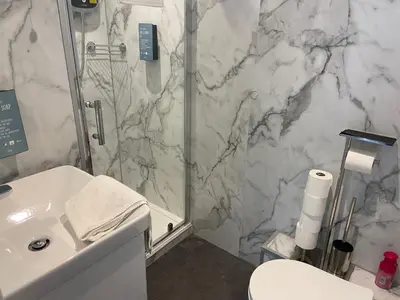 a bathroom with a shower and a sink and a toilet at Serenity Suites in Douglas