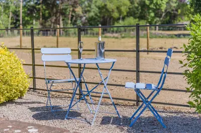 a table and two chairs sitting next to a fence at 1 Bed in Dalston oc-s32206 in Dalston