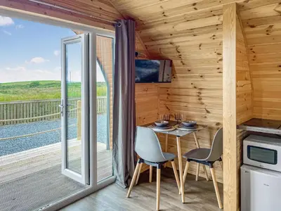 a dining room with a table and chairs and a balcony at Keith - Uk49287 in Stranraer